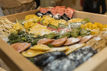 Display of a Food Store with Various Rows of Raw Coloured Pasta