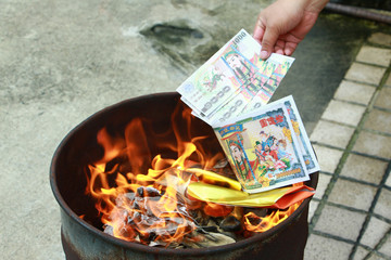 Burning the silver and gold fake money paper for chineses dead people  ancestors. Joss paper money...