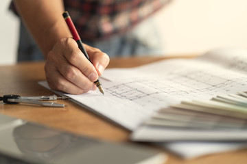 Architect & Engineer working drawing document about project planning and progress of work schedule on the home building construction site