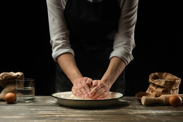 Cookery.The chef prepares the dough for pasta, pizza, bread, pancakes.Preparation and work with flour and dough.Delicious food, recipes, cooking, gastronomy, background for design