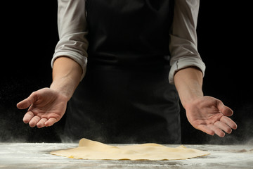 Chef works with dough, prepares pizza dough