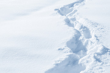 Fresh snow background texture. Winter background with snowflakes and snow mounds. Snow lumps. Footprints and traces.