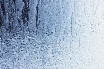 Frozen winter window pane coated shiny icy patterns. Frost background, closeup. Extreme north low temperature. Natural ice glass
