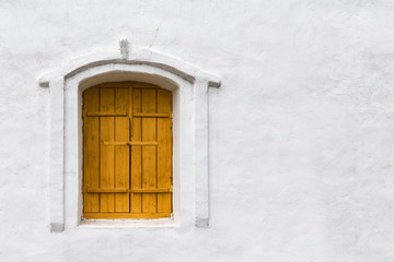 Old wooden window on the white concrete wall