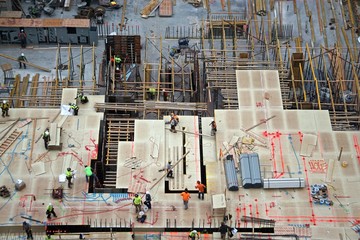 Aerial view of men and materials during construction of a new high-rise apartment building in...