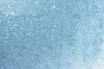 Fototapeta na wymiar Frozen winter window pane coated shiny icy patterns. Frost background, closeup. Extreme north low temperature. Natural ice glass