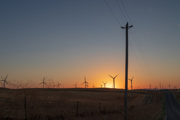 Obraz premium wind turbines turning in the hot, summer wind at sunset