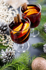 Two glasses of hot mulled wine with spices and sliced orange. Christmas drink with candle and decorations. Top view