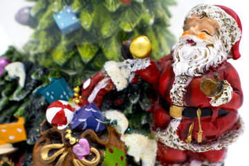 Glass ball with snow along with Santa Claus and gifts