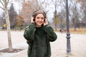 Smiling female listening to music in park