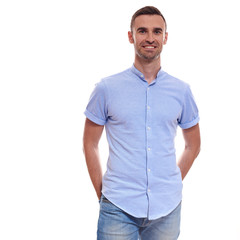 Obraz premium Casually handsome. Confident young handsome man in jeans shirt keeping arms crossed and smiling while standing against white background