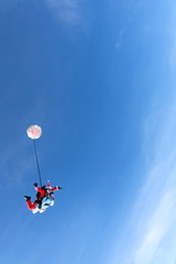 Obraz na płótnie Canvas Christmas skydiving. Santa Claus and little girl are in the sky.