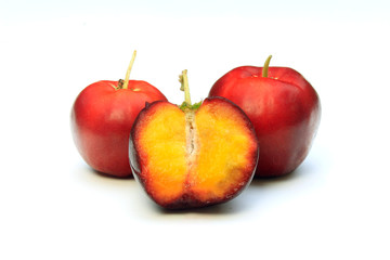 Fresh, whole and sliced organic acerolas, isolated on white background with clipping path