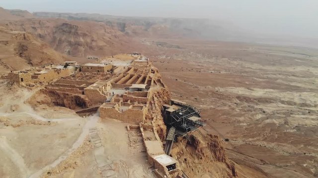 flying over Masada fortress area Southern District of Israel Dead Sea area Southern District of Israel. Ancient Jewish fortress of Roman Empire on top of a rock in Judean desert. view from the air