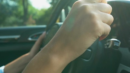 Inexperienced female driver turning steering wheel, passing driving test in city