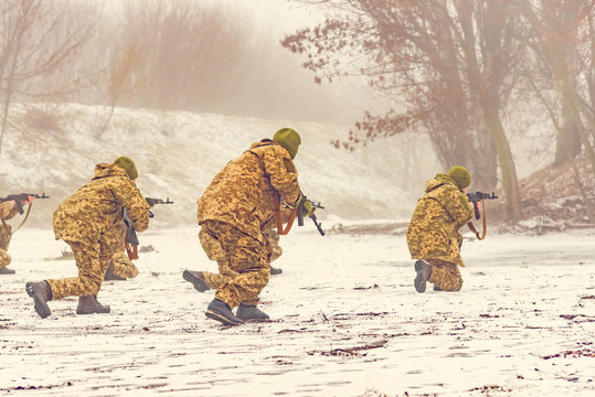 An assault brigade of paratroopers landed for stripping by special forces from the enemy. Military in the winter in the forest with machine guns.