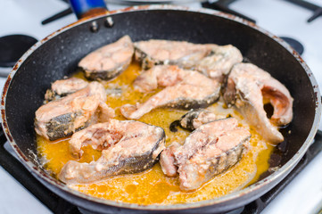 Stewed red salmon fish in tomato sauce in a frying pan