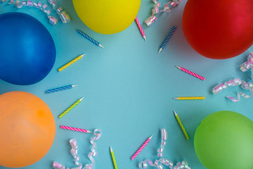 Colorful balloons,candles and confetti on the blue background.Top view.Copy space.