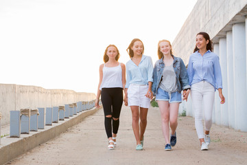 group of female friends walking outdoor, talking, having fun and smile. togethernes, friendship, lifestyle concept