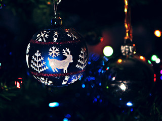 Christmas toy hanging on the tree in the dim light