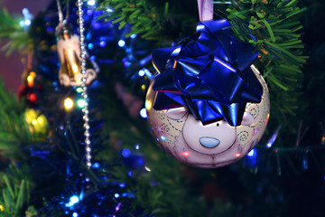 Christmas toy hanging on the tree in the dim light