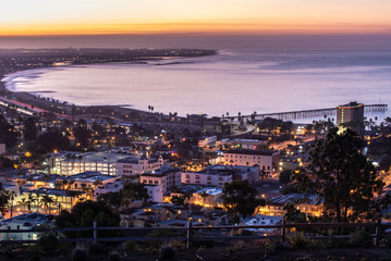 Downtown Ventura, California, USA is nestled against the Pacific Ocean coastline and lit up as the...