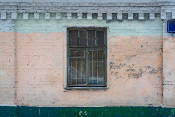Fototapeta na wymiar Brick wall of a building with a window and metal bars