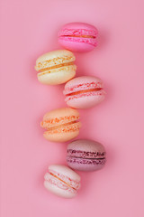 Obraz premium Top view of colorful macaron or macaroon on pink background.