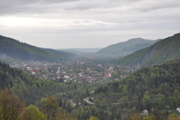 Panoramic view of the mountains. Ukrainian Carpathians view of the mountains and the city between them. Clouds over a mountain village in the Carpathians.