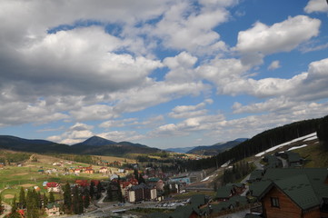 Panoramic view of the ski resort Bukovel. Ukrainian Carpathians view of the mountains and the city between them. Clouds over a mountain village in the Carpathians.