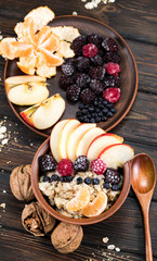 oatmeal with fruit on a wooden background