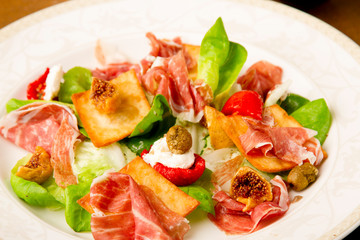 Fototapeta na wymiar jamon prosciutto with fig quail poached egg and dried olives