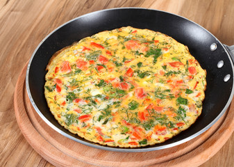 Omelette with tomatoes, parsley and cheese in pan