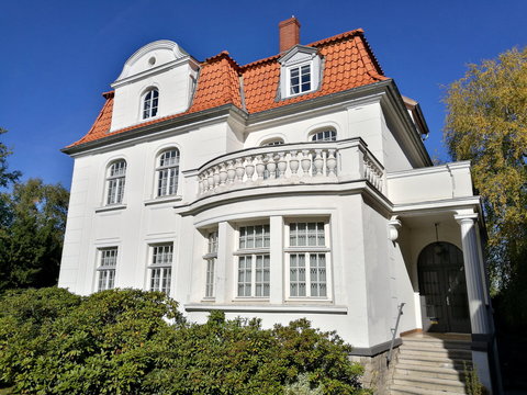 Sch&ouml;ne wei&szlig;e alte Villa mit Balkon vor strahlend blauem Himmel im Sonnenschein in der Alten Hansestadt Lemgo bei Detmold in Ostwestfalen-Lippe