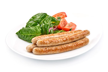 Grilled Thin Sausages with spinach and tomatoes, close-up, isolated on a white background
