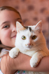 Little girl holding a cat.