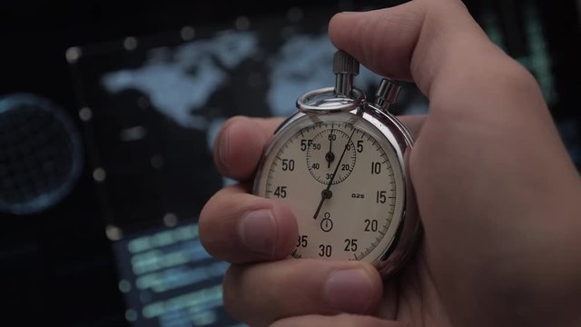 Close-up of one person starting up a stopwatch at hacker programmer screen background. Deadline concept. 4K, 10 BIT, 4:2:2