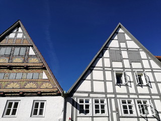 Restaurierte und kunstvoll verzierte schöne alte Fachwerkhäuser mit Spitzgiebel vor blauem Himmel...