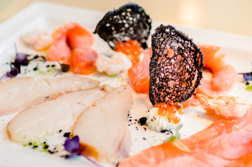 Fish cutting. Pieces of different fish on a plate with cream cheese and red caviar