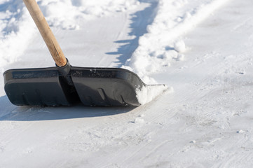 man cleans the snow in the yard