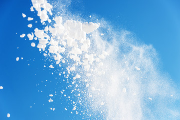 throwing snow into the air on a blue background