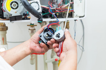 worker set up central gas heating boiler at home
