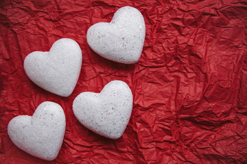 A lot of hearts on a red background. Concept for Valentine's Day or Women's Day or the topic of health, life, donation and help. In minimal style.