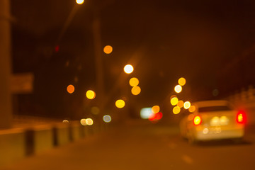 Artistic style - Defocused urban abstract texture ,blurred background with bokeh of city lights from car on street at night, vintage or retro color tone