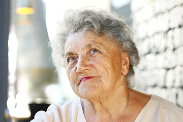Thoughtful elderly looking woman face with a white hair