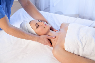 beautiful woman makes therapeutic massage of the face and neck massage therapist therapy