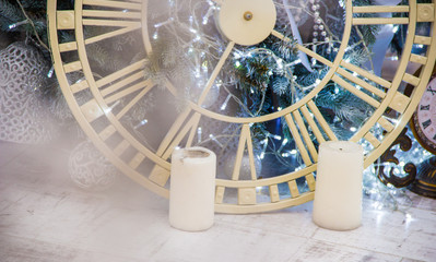 clock and candles near Christmas tree