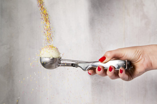 Scoop of lemon sorbet being sprinkled with hundreds and thousands.