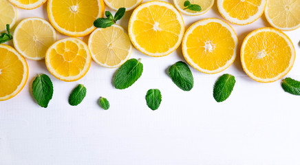 White background with lemon, orange slices and mint. Concept with fresh fruit. Lemon, Orange, Mint. View from above.