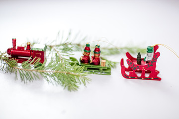 New Year's toys. Christmas trains with spruce branches on a light background.